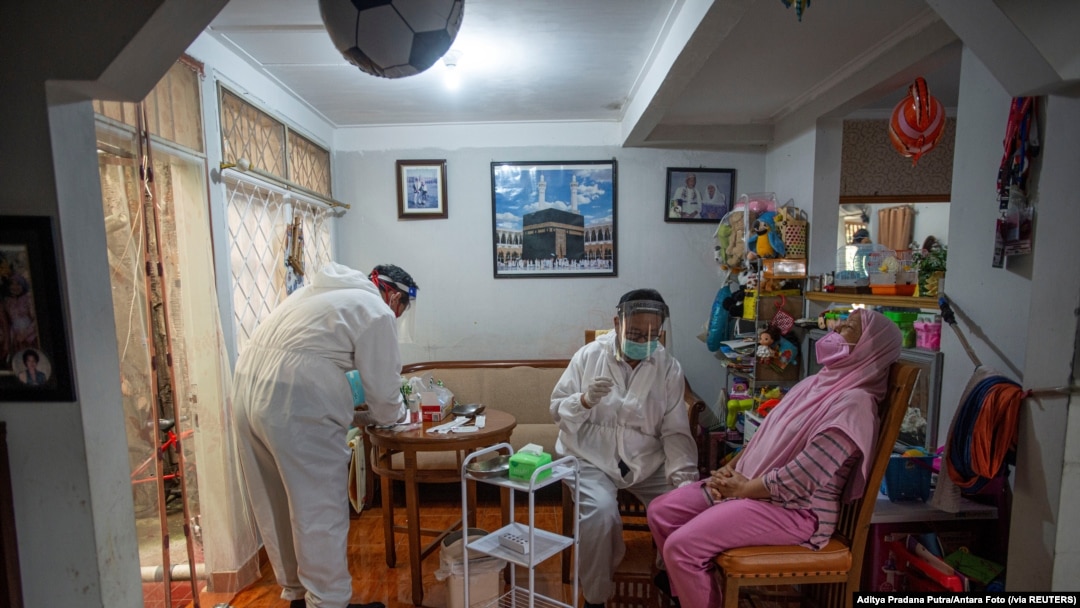 Para petugas kesehatan bersiap melakukan tes usap kepada seorang warga di tengah lonjakan kasus COVID-19, di Bogor, 7 Juli 2021. (Foto: Aditya Pradana Putra/Antara Foto via Reuters)