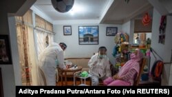 Para petugas kesehatan bersiap melakukan tes usap kepada seorang warga di tengah lonjakan kasus COVID-19, di Bogor, 7 Juli 2021. (Foto: Aditya Pradana Putra/Antara Foto via Reuters)