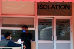 Men wear protective mask as a preventive measure against coronavirus, as they stand outside the Isolation ward at the Pakistan Institute of Medial Sciences (PIMS) in Islamabad, Pakistan, March 15, 2020.