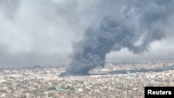 FILE - Drone footage shows birds in the foreground as clouds of black smoke billow over Bahri, also known as Khartoum North, Sudan, on May 1, 2023. 