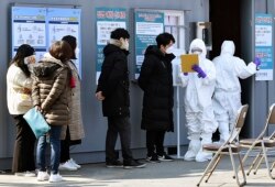 People suspected of being infected with the new coronavirus wait to receive tests at a medical center in Daegu, South Korea, Feb. 20, 2020. The mayor of Daegu urged its 2.5 million people Thursday to refrain from going outside as cases spike.