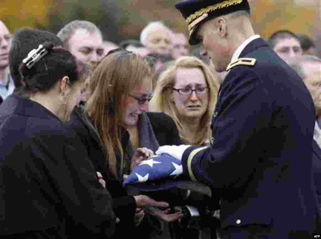 **RETRANSMITTING TO CORRECT SPELLING OF NAME TO LINDSEY NOT LYNDSEY** Brig. Gen. William E. Rapp, right, presents an American flag to Lindsey Paranzino, second left, during burial services for Sgt. Michael F. Paranzino in Middletown, R.I., Monday, Nov. 15