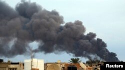 Un nuage de fumée s'élève d'une usine après une attaque aérienne des forces fidèles à l'ancien général Khalifa Haftar, à Benghazi, Libye, 22 octobre 2014.