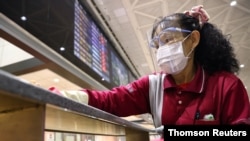 资料照片-一名戴着防护口罩的工作人员在新冠肺炎大流行期间清洁台湾桃园国际机场。（2021年1月7日）