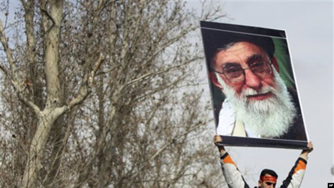 A pro-government Iranian holds a poster of supreme leader Ayatollah Ali Khamenei during the funeral ceremony of Sane Jaleh, a student who was killed during Monday's clashes, in Tehran, Iran, February 16, 2011