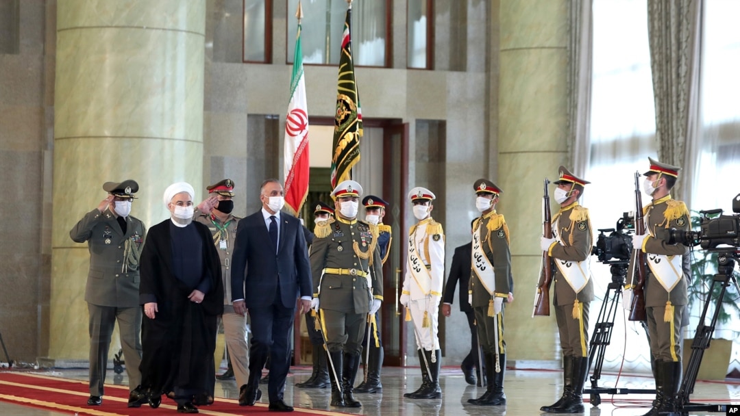 PM Irak Mustafa al-Kadhimi (keempat dari kiri), disambut barisan kehormatan saat diterima oleh Presiden Hassan Rouhani (kedua dari kiri) setibanya di Teheran, Iran, di tengah pandemi Covid-19, 21 JUli 2020. (Iranian Presidency Office via AP)