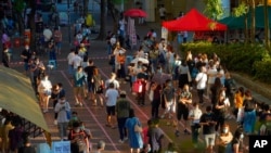 People queue up to vote in Hong Kong, Sunday, July 12, 2020, in an unofficial primary for pro-democracy candidates ahead of legislative elections in September.