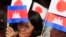 In this file photo taken on March 13, 2018, Cambodians hold Japan's flags and their national flags as they listen to Prime Minister Hun Sen's speech during an inauguration ceremony of a road funded by Japan for its official use at Kdey Takoy village, Phnom Penh, Cambodia.