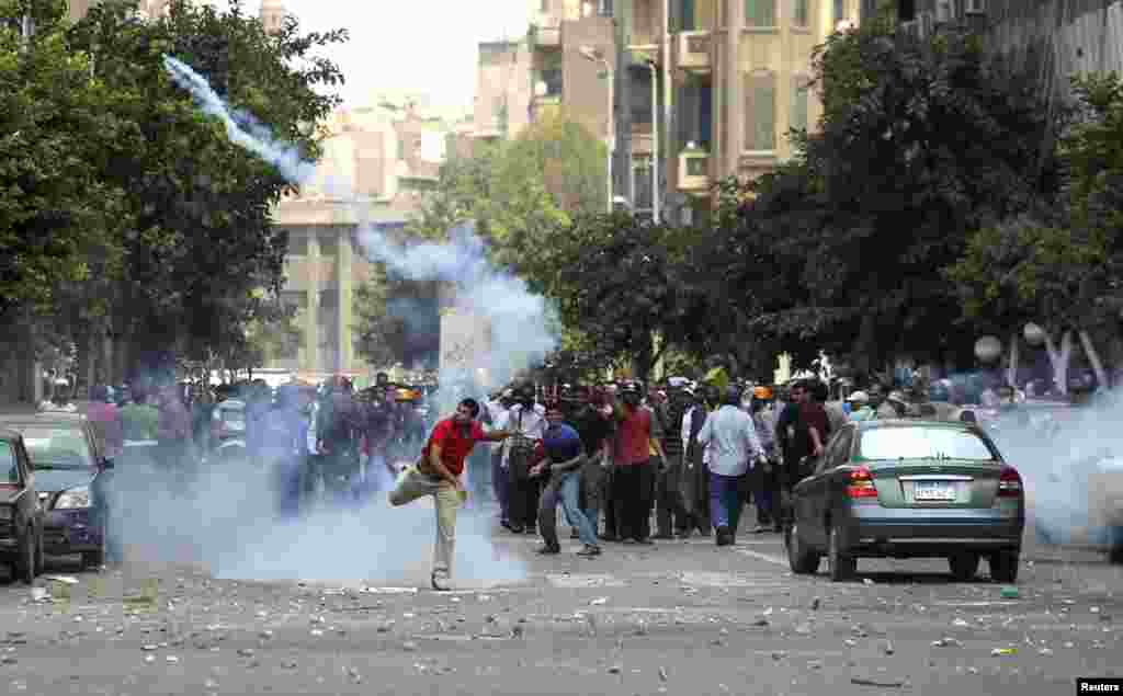 Một người ủng hộ Tổng thống bị lật đổ Mohamed Morsi ném một hộp hơi cay về phía cảnh sát trong cuộc đụng độ ở trung tâm Cairo, 13 tháng 8, 2013.