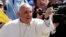 Pope Francis catches a rosary thrown by faithful as he arrives to lead his Wednesday general audience in Saint Peter's Square at the Vatican, June 5, 2013. 