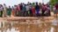 Residents gather for a planned distribution of food, after El Niño rains damaged their houses in Bangale town in Tana River county, Kenya, Sunday, Nov. 26, 2023.