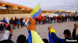 Venezuelan migrants pray after a U.S. judge declared Title 42 used to expel migrants from the United States as illegal at a camp on the banks of the Rio Bravo river, in Ciudad Juarez