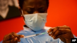 A nurse prepares a syringe of the COVID-19 vaccine, at the Notre Dame de Stockel care home in Sint-Pieters-Woluwe, Belgium, Dec. 28, 2020. 