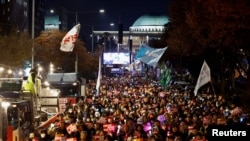 9일 한국 여의도 국회의사당 앞에 시민들이 모여 윤석열 한국 대통령의 비상계엄 선포에 따른 탄핵 요구 집회를 벌이고 있다.