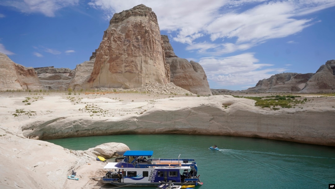 Sebuah rumah kapal bersandar di teluk kecil yang menjadi bagian dari Danau Powell di Page, Arizona, pada 30 Juli 2021. Pada musim panas 2021, level ketinggian air di danau tersebut mencapai titik terendah dalam sejarah akibat kekeringan yang melanda. (Foto: AP/Rick Bowmer)