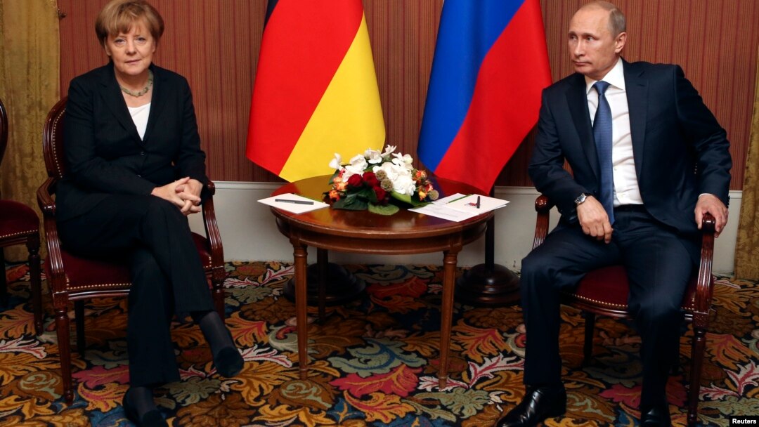 FILE - Russian President Vladimir Putin meets with German Chancellor Angela Merkel in Deauville, Northern France, June 6, 2014.