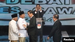 Kandidat Capres-Cawapres Prabowo Subianto-Hatta Rajasa (kiri) menyalami Joko Widodo-Jusuf Kalla sebelum acara debat di Jakarta, Senin (9/6).