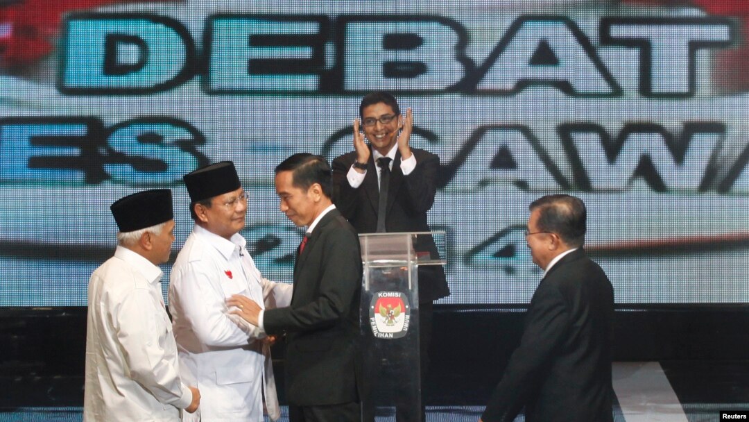 Kandidat Capres-Cawapres Prabowo Subianto-Hatta Rajasa menyalami Joko Widodo-Jusuf Kalla sebelum acara debat di Jakarta, Senin (9/6).