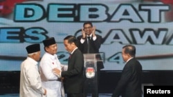 Kandidat Capres-Cawapres Prabowo Subianto-Hatta Rajasa menyalami Joko Widodo-Jusuf Kalla sebelum acara debat di Jakarta, Senin (9/6).