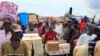 FILE - People carry items into Haiti from the Dominican Republic in Malpasse, Haiti, April 1, 2010.