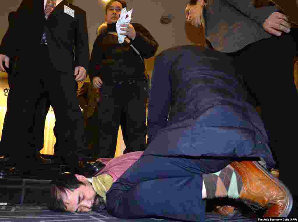 A man (bottom center) who attacked U.S. ambassador to South Korea Mark Lippert is detained by police at the Sejong Cultural Institute in Seoul, March 5, 2015.