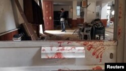 Blood stains a door following a twin bombing inside a mosque in Benghazi, Libya, Feb. 9, 2018.