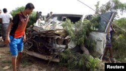 Warga memeriksa sebuah mobil yang rusak pasca ledakan bom mobil di kota Aden, Yaman selatan, Selasa (5/1).