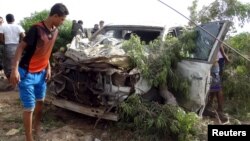 A man looks at a damaged car at the site of a car bomb attack in Yemen's southern port city of Aden, Jan. 5, 2016. Three senior southern Yemeni officials survived a suicide car bomb attack on their convoy in Aden.