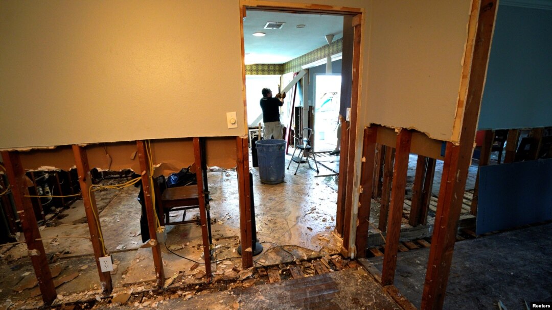 A man tears out Hurricane Harvey flood damage from a home in southwestern Houston, Texas, Sept. 2, 2017.