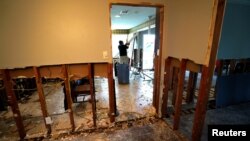 A man tears out Hurricane Harvey flood damage from a home in southwestern Houston, Texas, Sept. 2, 2017.