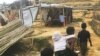 Rohingya refugees walk along a litter-strewn path next to makeshift tents at a camp in Bangladesh.