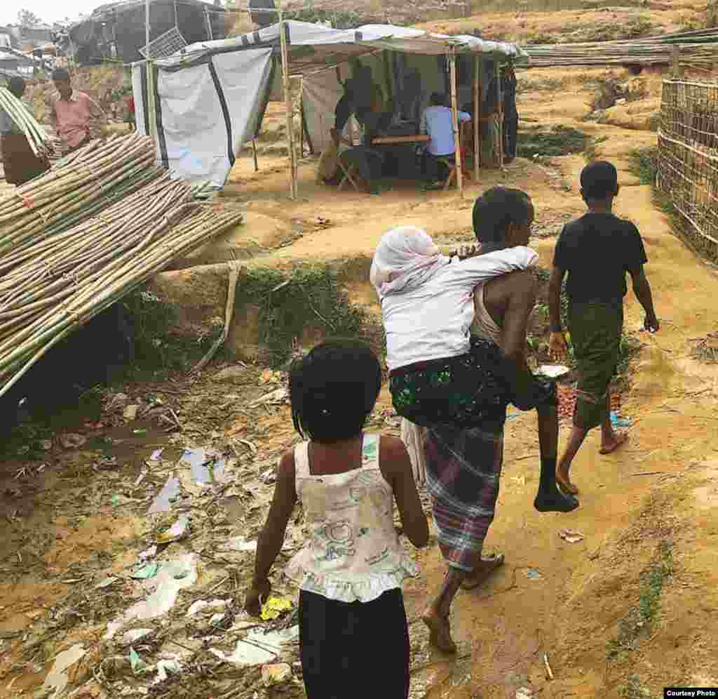 Pengungsi Rohingya berjalan di sepanjang jalan setapak yang dipenuhi sampah di samping tenda-tenda di sebuah kamp pengungsi di Bangladesh. (Foto: Dr. Imran Akbar) &nbsp;