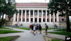 Siswa berjalan di dekat Perpustakaan Widener di Universitas Harvard di Cambridge, Massachusetts, 13 Agustus 2019. (Foto: AP)