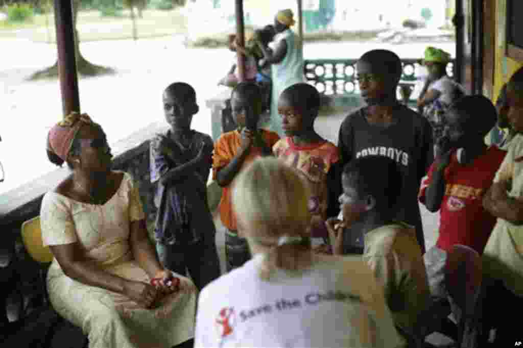 Carolyn Miles, au premier plan, présidente et chef de la direction de Save the Children, discutent avec des orphelins dans la ville d&rsquo;Unification, Libéria, à quelques 40 km (25 miles) de la capitale Monrovia, vendredi le 3 octobre 2014. 