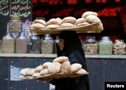 A woman carries bread as she leaves a bakery in Cairo, Egypt Jan. 10, 2017.