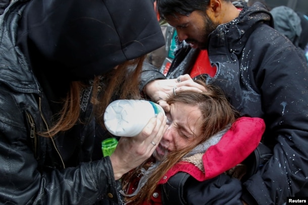 Una mujer es atendida luego de ser afectada por gas pimienta durante las protestas anti-Trump en Washington.