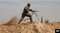 FILE - Shiite fighter clashes with members of the Sunni-dominated Free Syrian Army rebel in the town of Hatita, in the countryside of Damascus, Syria. 