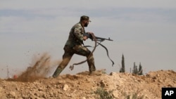 FILE - A Shi'ite fighter clashes with members of the Sunni-dominated Free Syrian Army rebel in the town of Hatita, in the countryside of Damascus, Syria, Nov. 22, 2013.