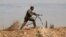 FILE - A Shi'ite fighter clashes with members of the Sunni-dominated Free Syrian Army rebel in the town of Hatita, in the countryside of Damascus, Syria, Nov. 22, 2013.