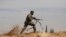 FILE - Shiite fighter clashes with members of the Sunni-dominated Free Syrian Army rebel in the town of Hatita, in the countryside of Damascus, Syria. 