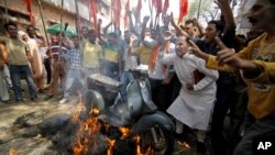 Hindu nationalist Shiv Sena activists burn a scooter during a nationwide strike to protest a steep hike in gas prices in Jammu, India, May 31, 2012. 