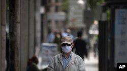 Un hombre con un tapabocas para combatir la propagación del coronavirus espera para ingresar a una tienda en Madrid, España, el jueves 7 de mayo de 2020.