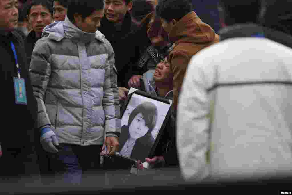Relatives cry as they hold a picture of a victim of the stampede incident during a New Year&#39;s celebration at the Bund, a waterfront area of Shanghai, China, Jan. 6, 2015.