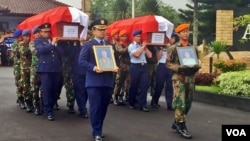 Dua jenazah korban kecelakaan pesawat T50i Golden Eagle; Letkol Marda Sarjono (kiri) dan Kapten Dwi Cahyadi (kanan) diberi penghormatan dan diserahkan kepada keluarga (dari TNI AU) di Base Ops Lanud Adisucipto, Minggu (20/12) petang (VOA/Munarsih).