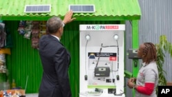 FILE - Then-President Barack Obama looks at a solar power exhibit during a tour of the Power Africa Innovation Fair, July 25, 2015, in Nairobi, Kenya. With technical help from the U.N. Industrial Development Organization, a cooperative in Olosho-Oibor installed solar panels on poles around the community and on rooftops. It has installed two small wind turbines as well.