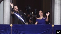 El presidente de El Salvador, Nayib Bukele, y la primera dama, Gabriela Roberta Rodríguez, saludan desde un balcón después de que fuera juramentado para un segundo mandato, en San Salvador, El Salvador, el 1 de junio de 2024.