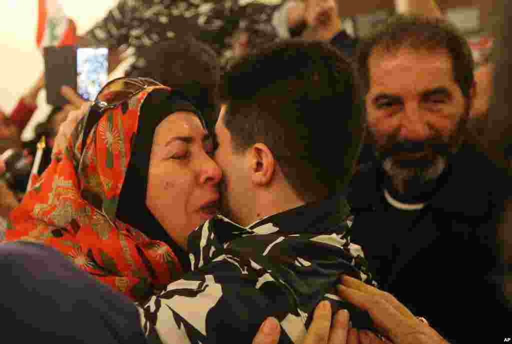 A Lebanese policeman, center, who was kidnapped by Nusra Front, hugs his mother, left, upon his arrival at the government palace, in Beirut. Syria&#39;s al-Qaida branch released a group of Lebanese troops held captive for over a year as part of a Qatar-brokered swap that involved Lebanon setting free at least 11 prisoners wanted by the militants, including a former wife of the Islamic State leader Abu Bakr al-Baghdadi.