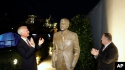 U.S. Ambassador in Germany Richard Grenell, right, and Secretary of State Mike Pompeo unveil a statue of former President Ronald Reagan on the top of United States embassy in Berlin, Nov. 7, 2019. 