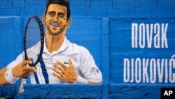 Sebuah mural yang menggambarkan pemain tenis Serbia Novak Djokovic di dinding di Beograd, Serbia, Kamis, 6 Januari 2022. (Foto: AP)