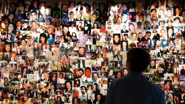 资料照片：2021年8月6日在纽约的9/11博物馆，9/11 世贸中心袭击幸存者德西雷·布沙 (Désirée Bouchat) 看着遇难者的照片。